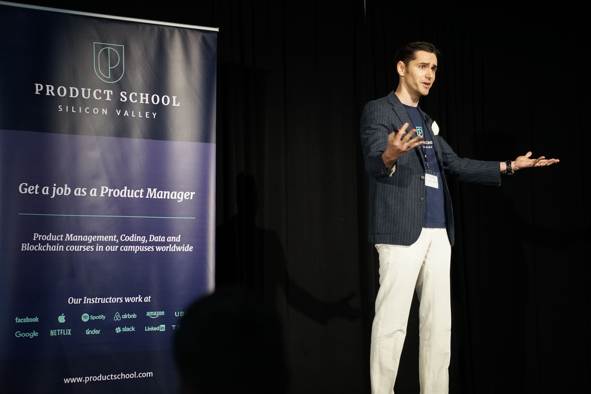 ステージで観衆に問いかける男性